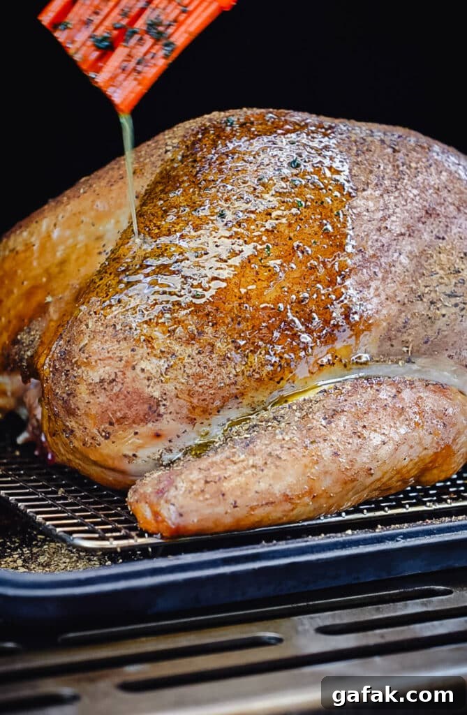 How to Smoke a Turkey: Step-by-Step Guide for Juicy Results 2 turkey breast being basted with melted butter inside of a smoker