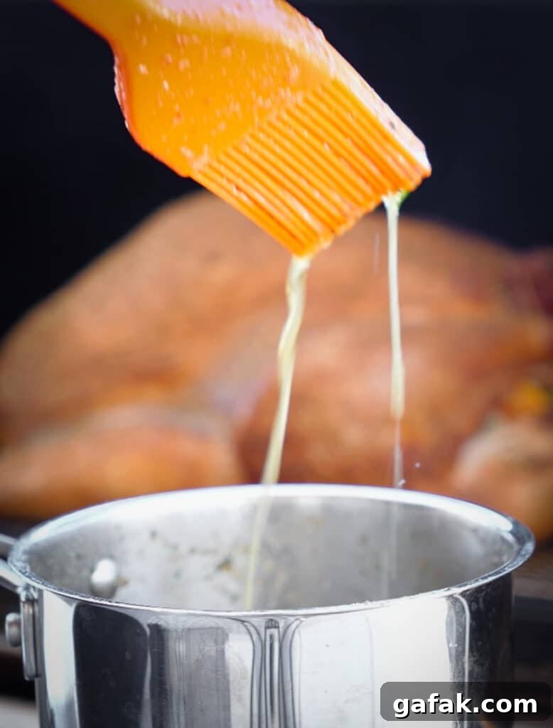 How to Smoke a Turkey: Step-by-Step Guide for Juicy Results 11 melted butter dripping off of a basting brush