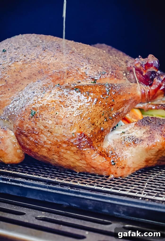 How to Smoke a Turkey: Step-by-Step Guide for Juicy Results 12 basting a turkey leg with melted butter inside of a smoker