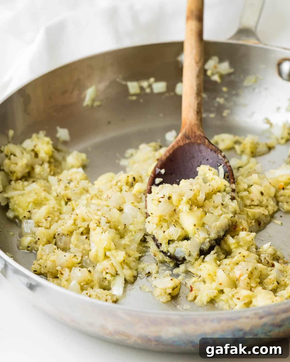 Sauteing the zucchini and veggies with spices in a skillet.