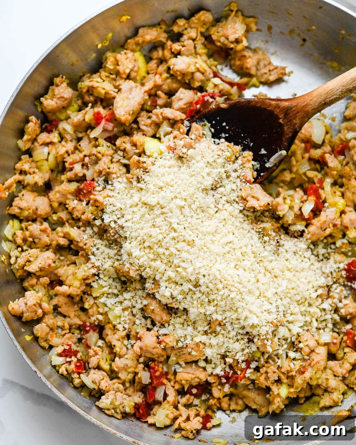 Folding breadcrumbs into the chicken sausage stuffing for the zucchini shells.