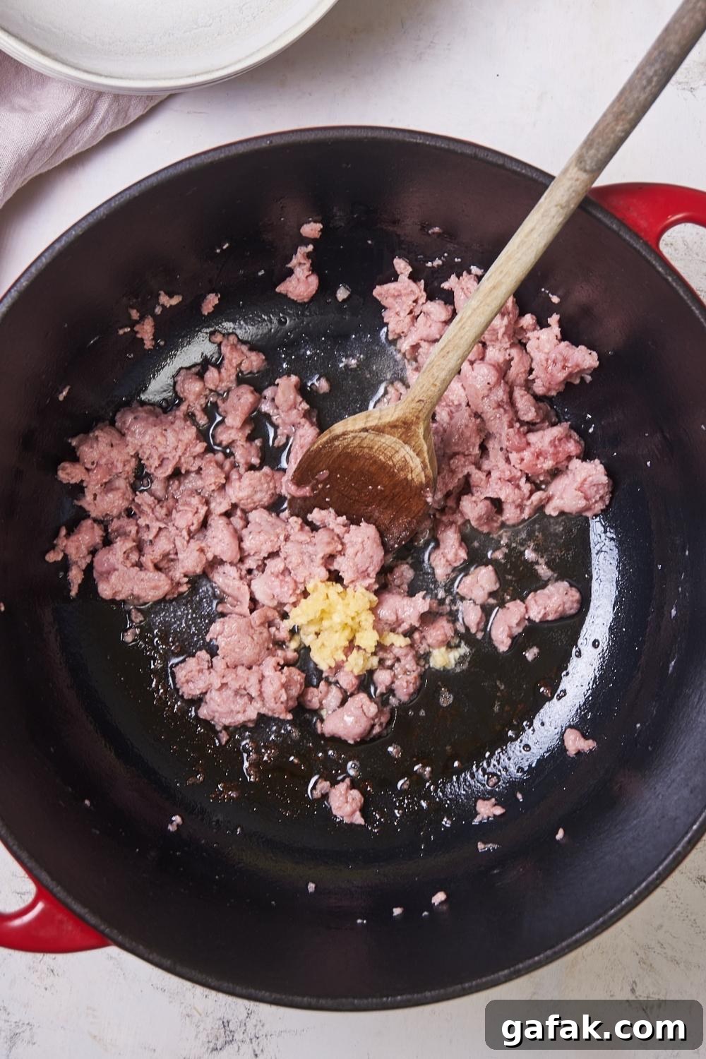 A large pot with sausage being cooked in it.