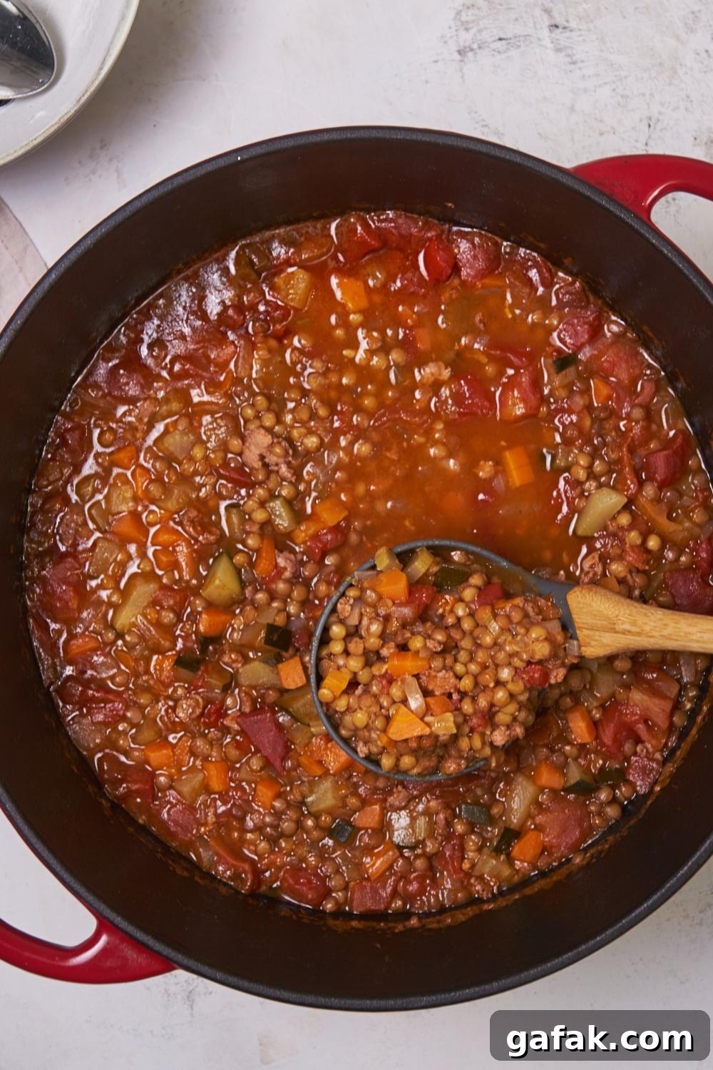 A large pot with homemade Carrabba's lentil soup. A ladle is scooping it.