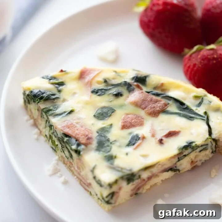 slice of Instant Pot frittata on white plate with fresh strawberries