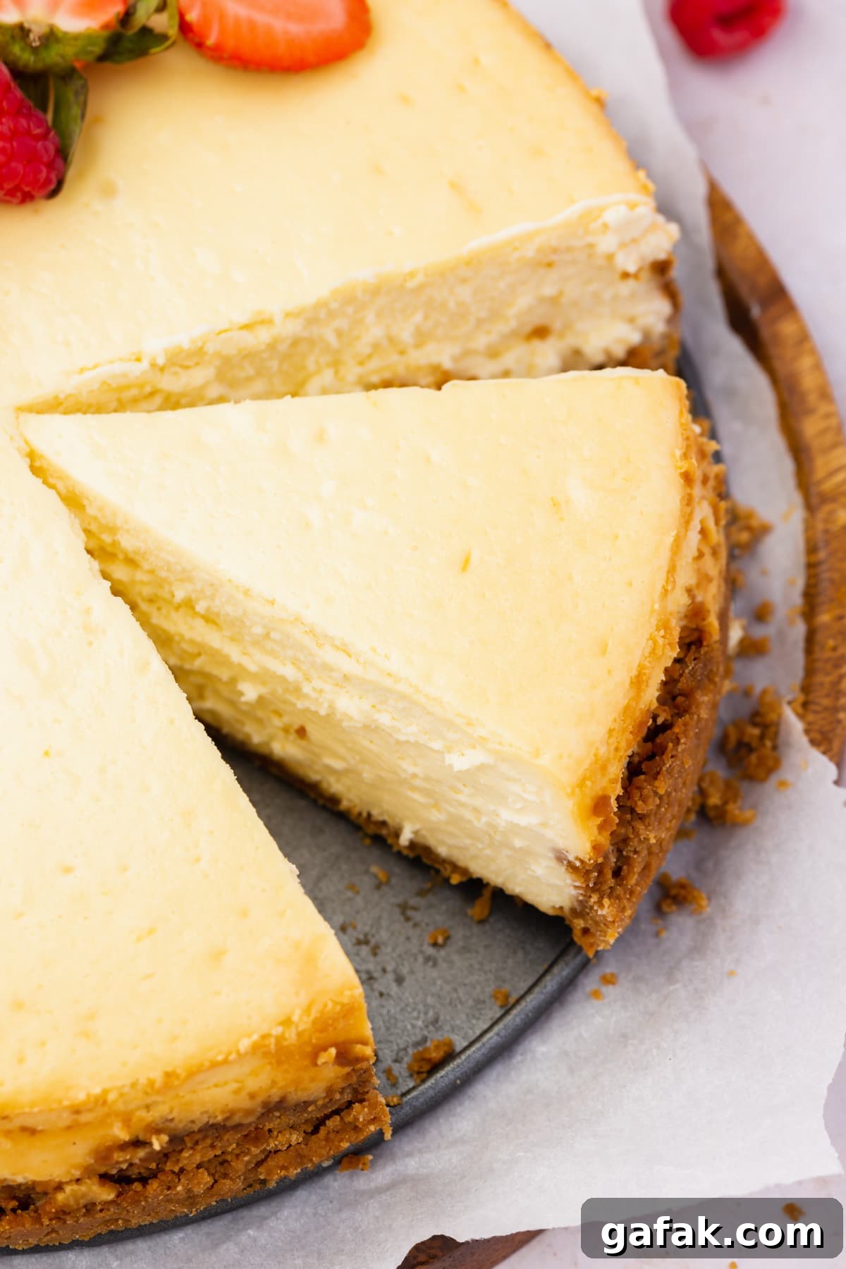 A close up of a slice of gluten-free cheesecake with a graham cracker crust.