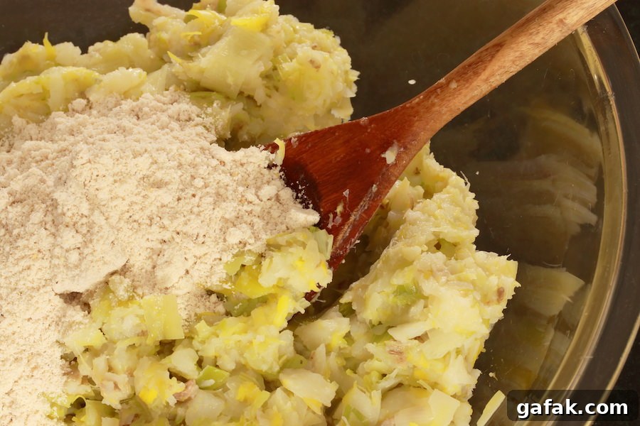 Cooked potatoes and leeks rough chopped; dry ingredients poured on top ready to be mixed