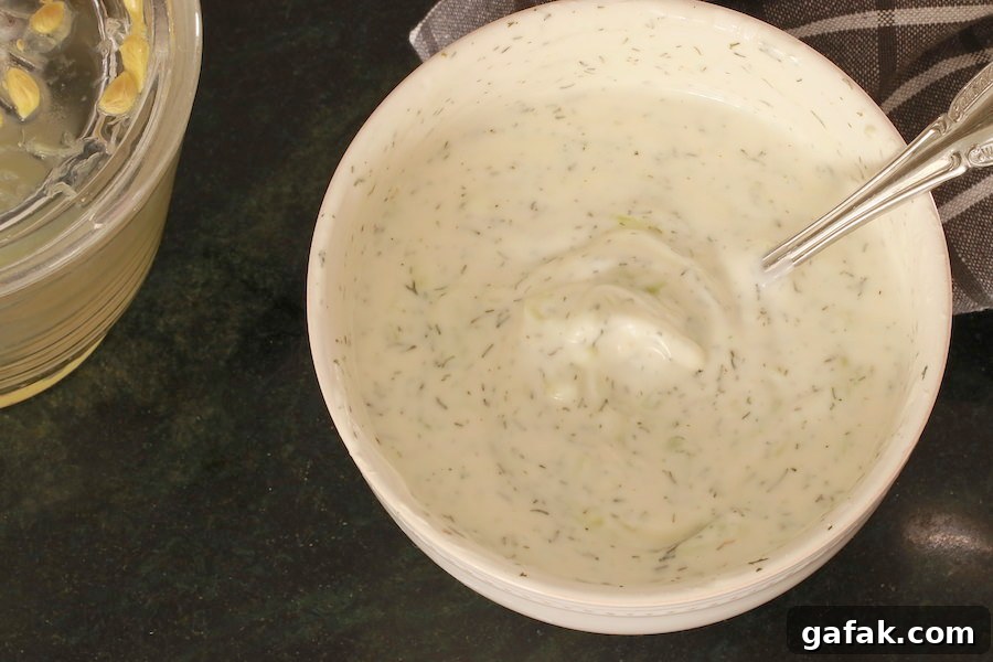 Tzatziki Sauce in a bowl with a glimpse of lemon squeezer and napkin in the background