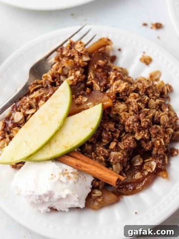 Apple crisp on a plate with whipped cream