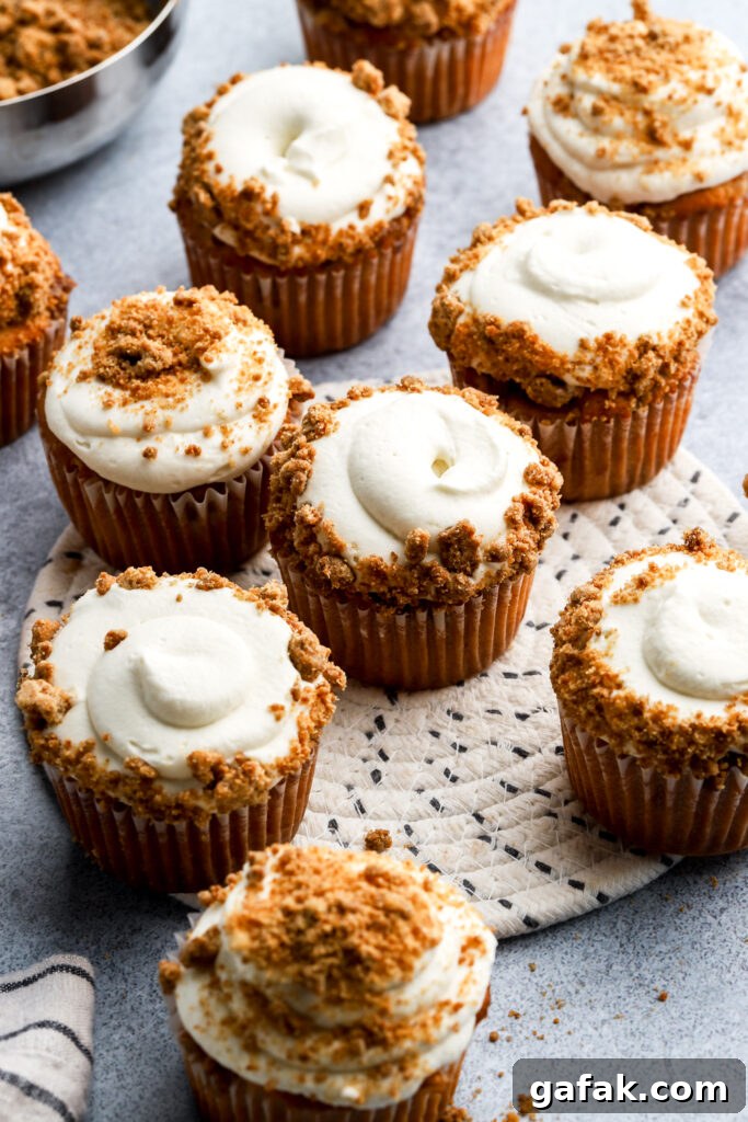 apple pie cupcakes frosted with whipped cream frosting and topped with streusel topping
