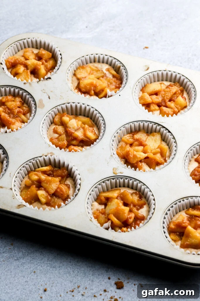 apple pie topping on top of cupcakes before baking