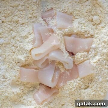 Calamari rings on flour ready for tossing.