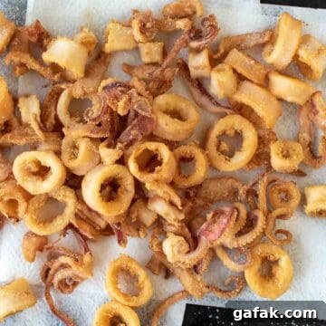 Fried calamari rings and tentacles on paper towel.