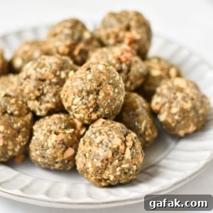 A stack of no bake balls with oatmeal on a gray plate next to chia seeds and oats.