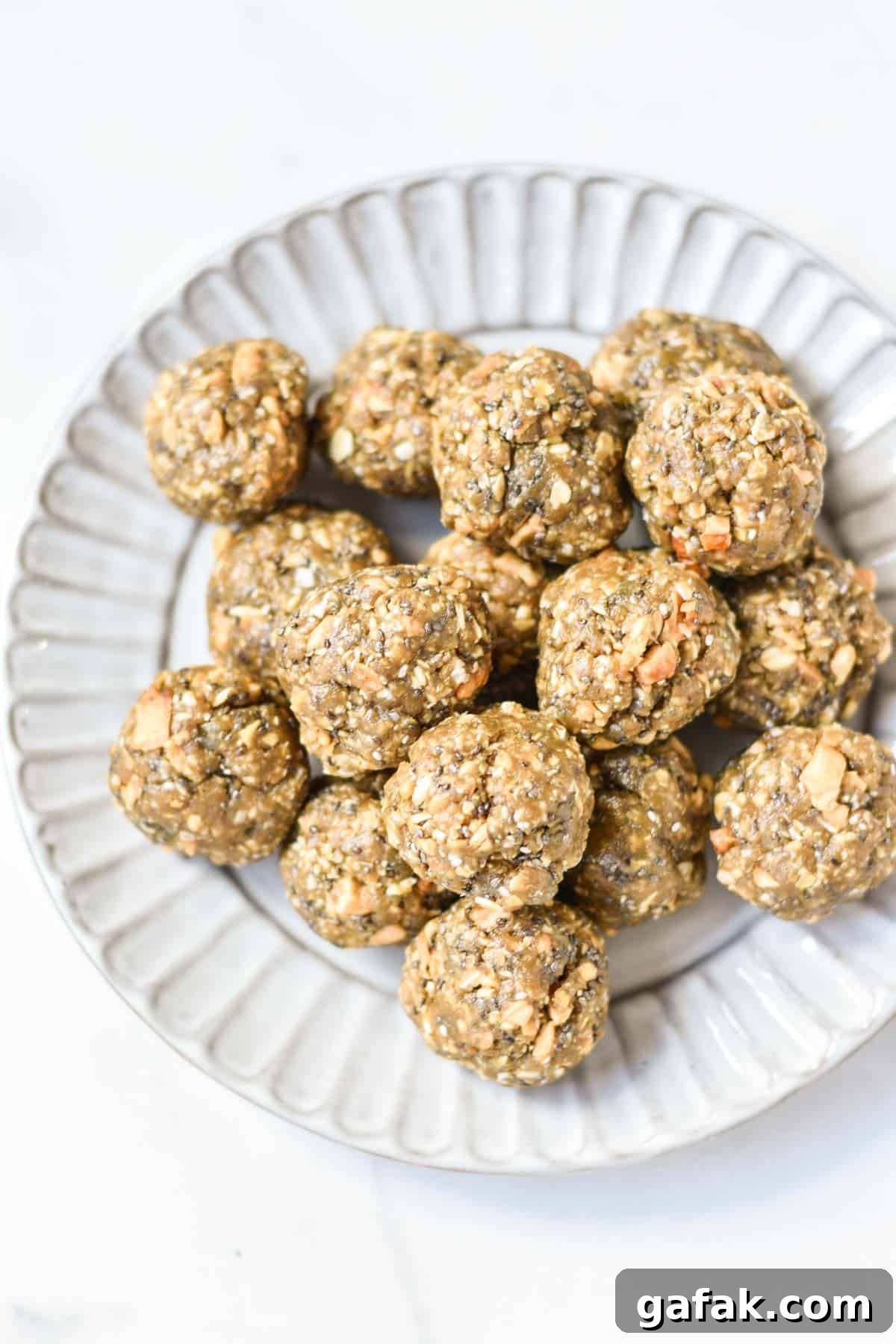 Stacked oatmeal energy balls on a scalloped edge plate.