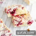 A close up picture of two white chocolate raspberry blondies stacked on each other.