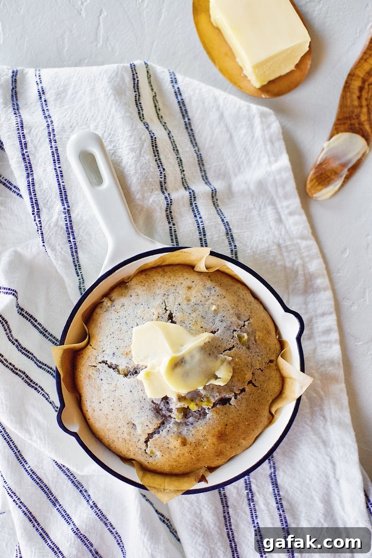 Blue Cornbread in a skillet with butter spread on top.