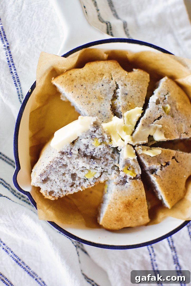 Blue Cornbread in a skillet with butter spread on top.