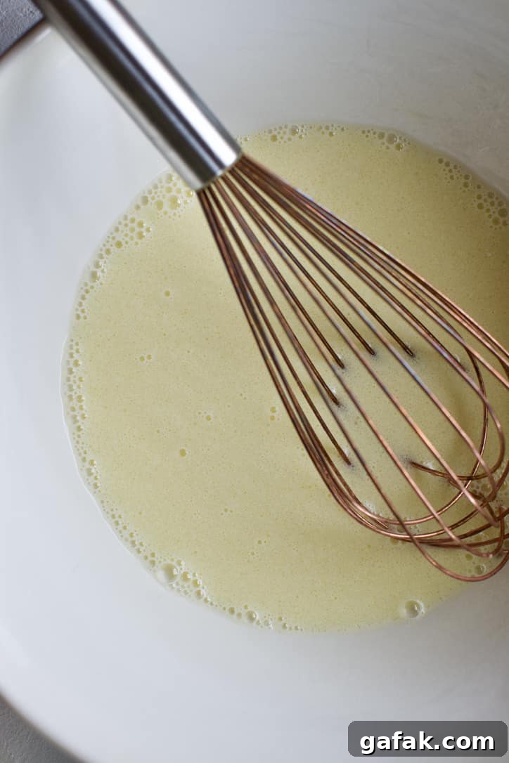 Eggs, Milk, and Oil in a bowl, whisked together.