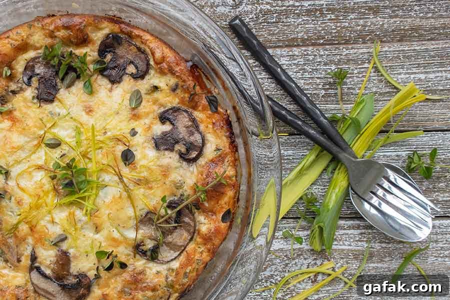 baked crustless quiche with leeks mushrooms and fontina cheese in a pie dish