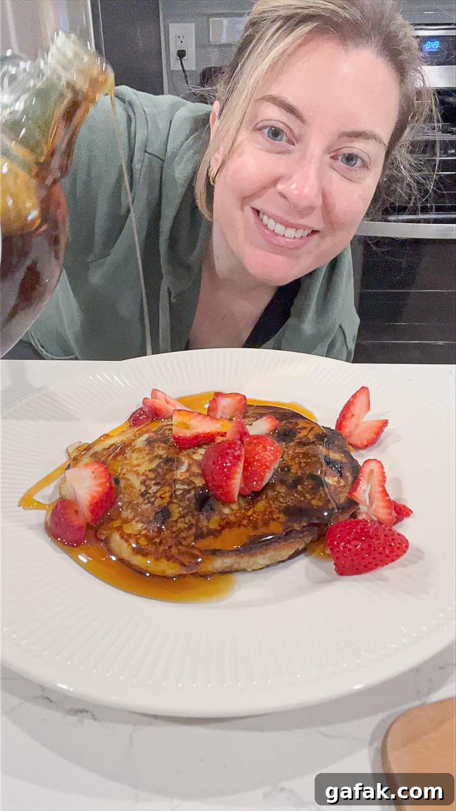 Pouring Maple Syrup On Grated Apple Pancakes With Blueberries