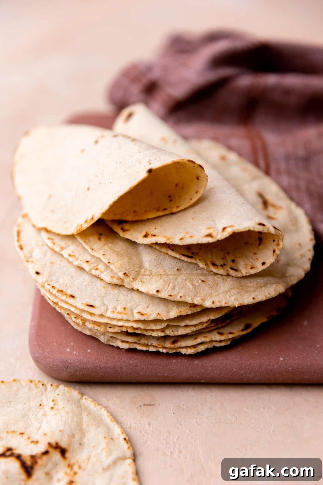 Stack of homemade corn tortillas folded over. 