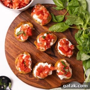 Toast topped with ricotta and bruschetta on a cutting board.