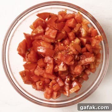 Chopped tomatoes, drained, in a bowl.