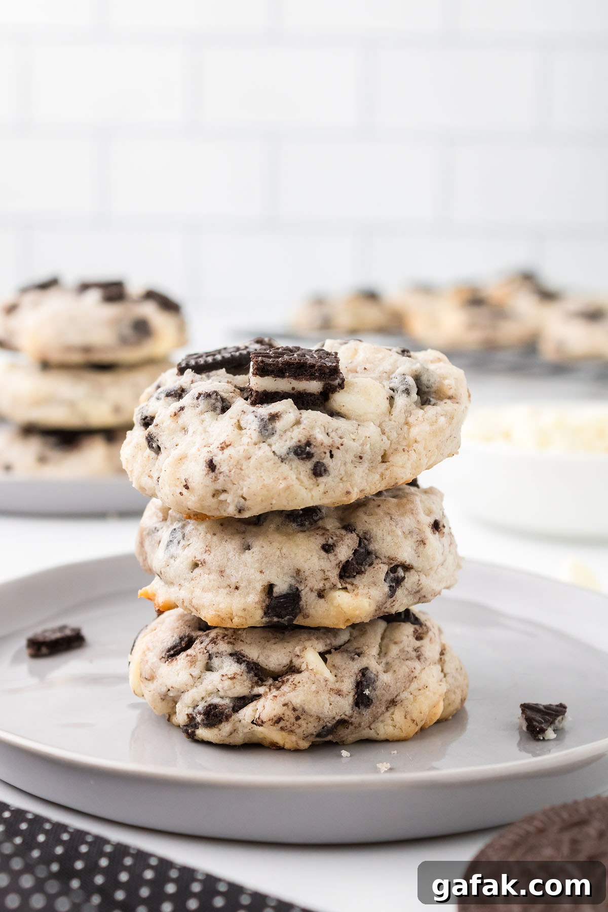 Three Cookies and Cream Cheesecake Cookies stacked on a white plate.