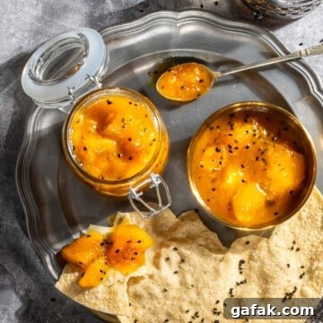 Indian mango chutney in a jar and a bowl with some poppadoms on a plate.