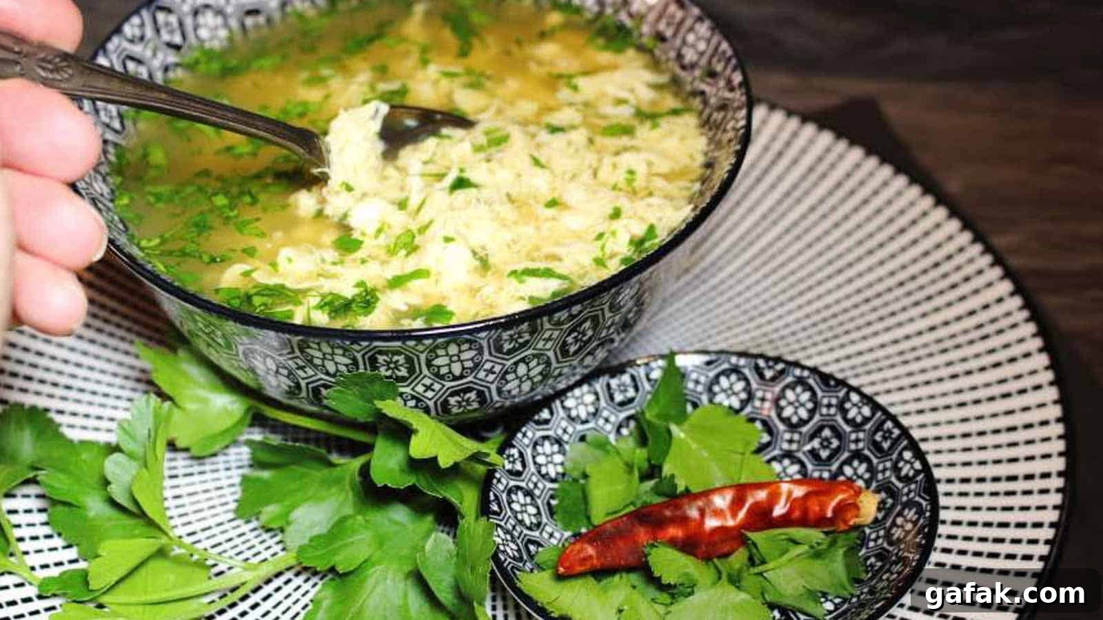 21 Packed Lunch Ideas to Make Midday Meals Exciting Again 12 Egg Drop Soup inside blue bowl with spoon.