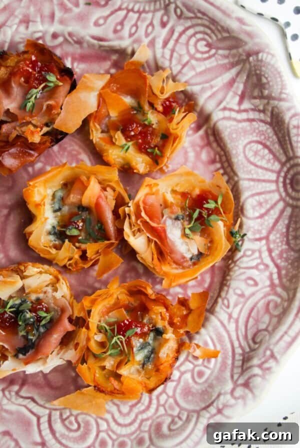 Baked blue cheese, prosciutto, sweet chilli bites on a small pink plate.