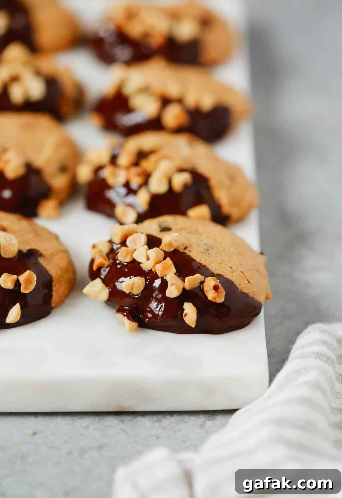 Close up of a low-carb peanut butter cookies dipped in chocolate and topped with chopped peanuts. 