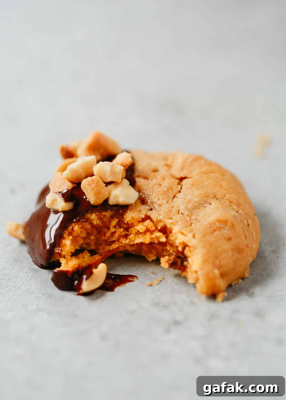 Close up of a peanut butter cookie with a bite taken out.