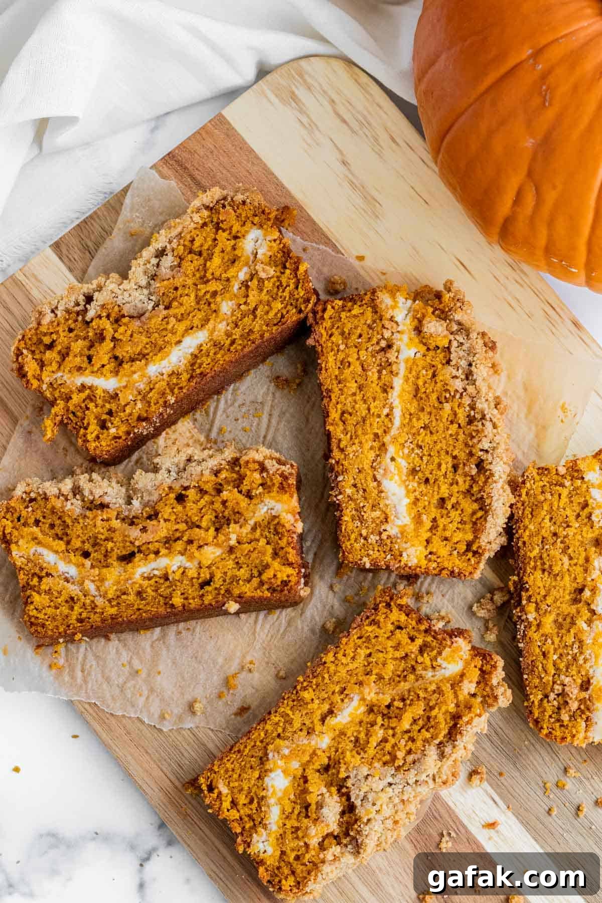 slices of pumpkin cream cheese bread laying on a wooden cutting board