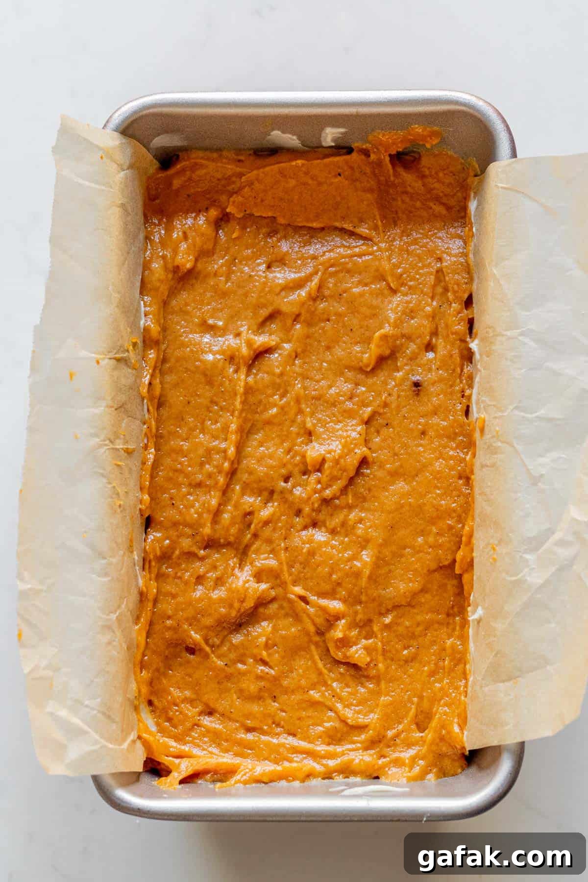 pumpkin bread batter in a loaf pan