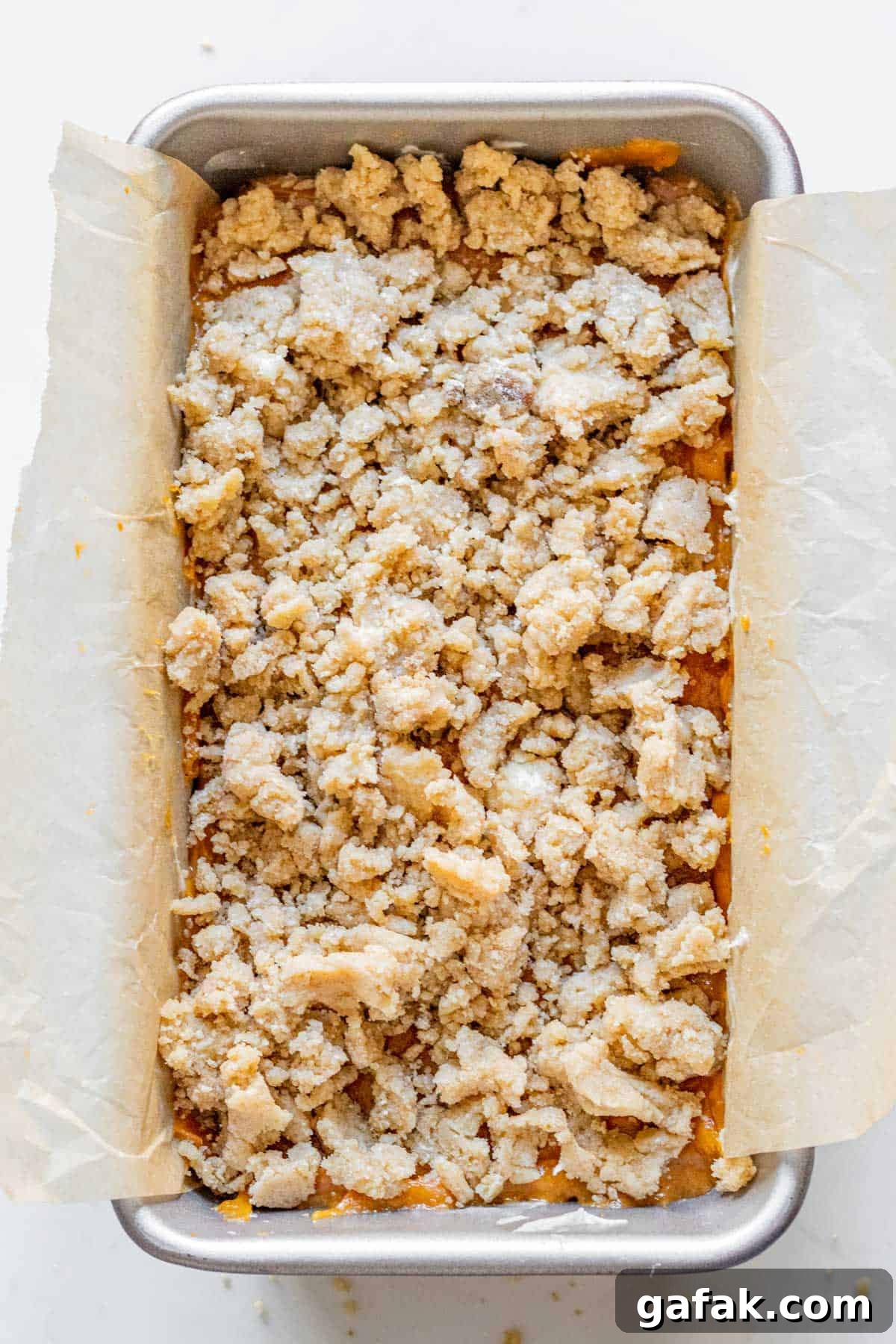 pumpkin bread batter with a streusel topping in a loaf pan