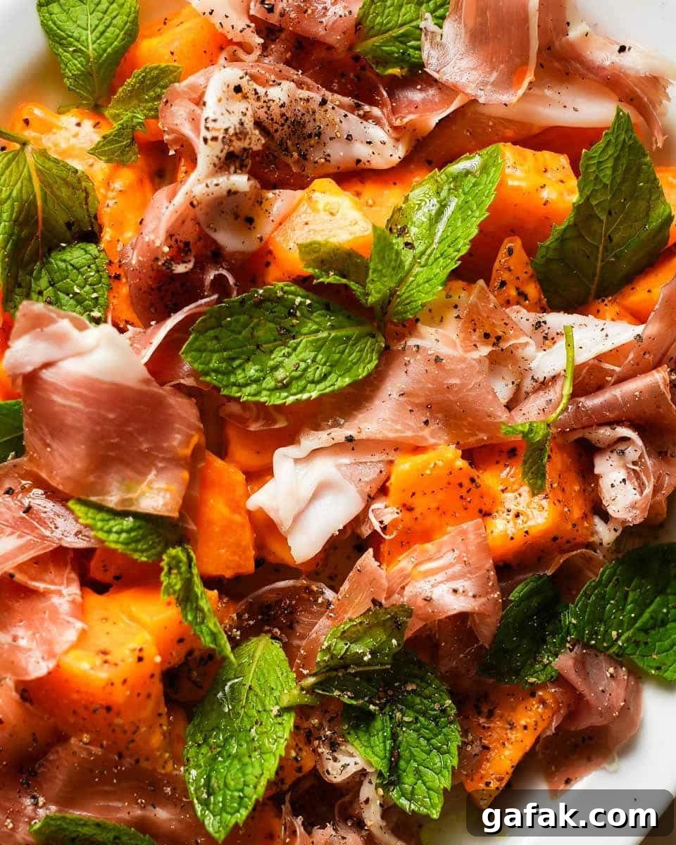 Melon and prosciutto salad with fresh mint leaves and cracked pepper.