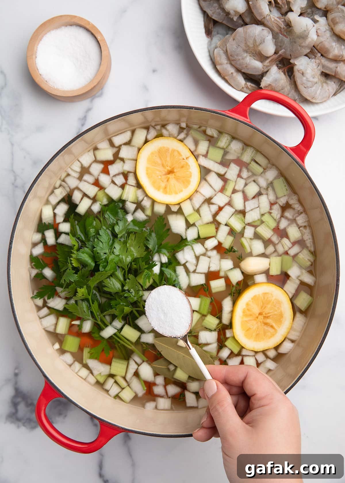How to Poach Shrimp Perfectly Every Time 5 adding salt to a pot of court bouillon ingredients