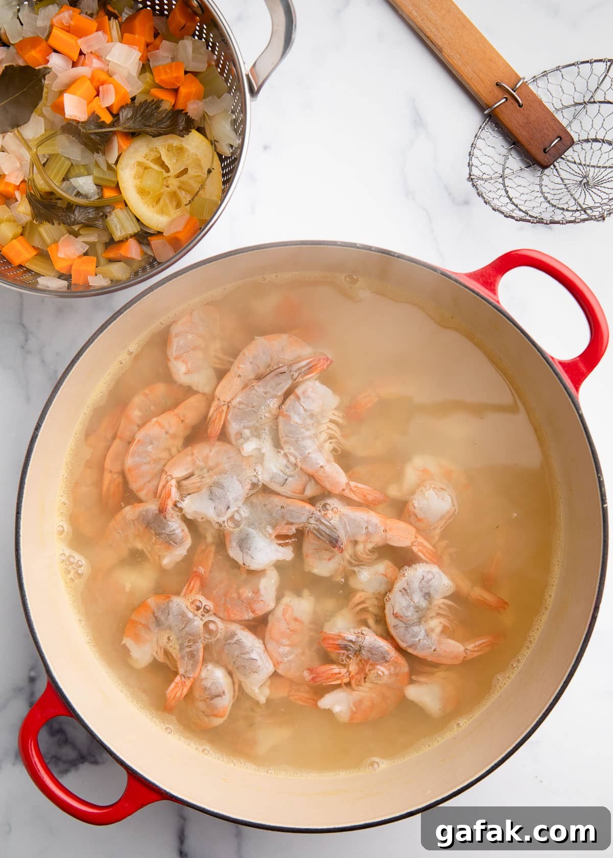 How to Poach Shrimp Perfectly Every Time 8 raw shrimp added to poaching liquid in a Dutch oven