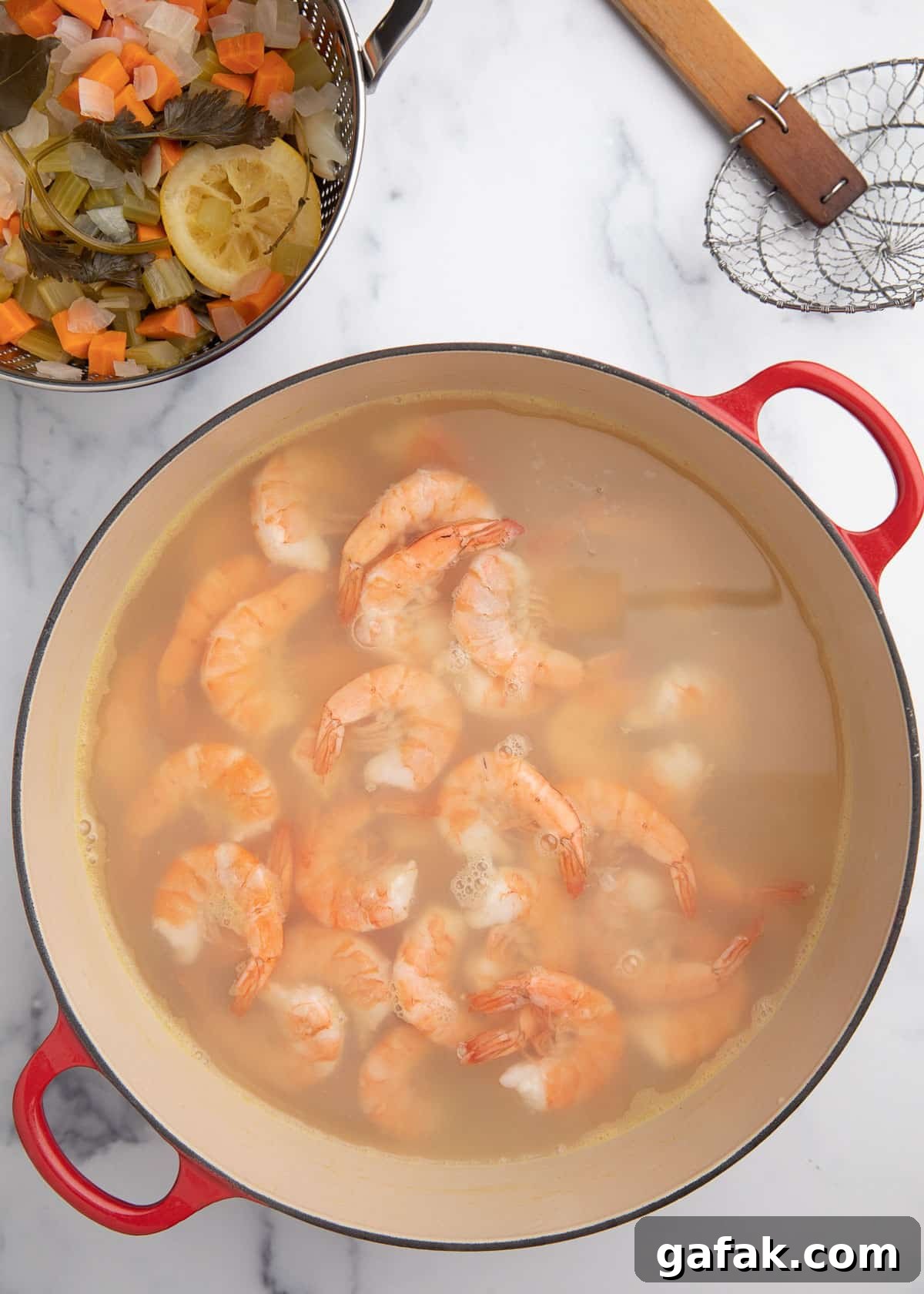 How to Poach Shrimp Perfectly Every Time 10 poached shrimp in cooking liquid in a Dutch oven