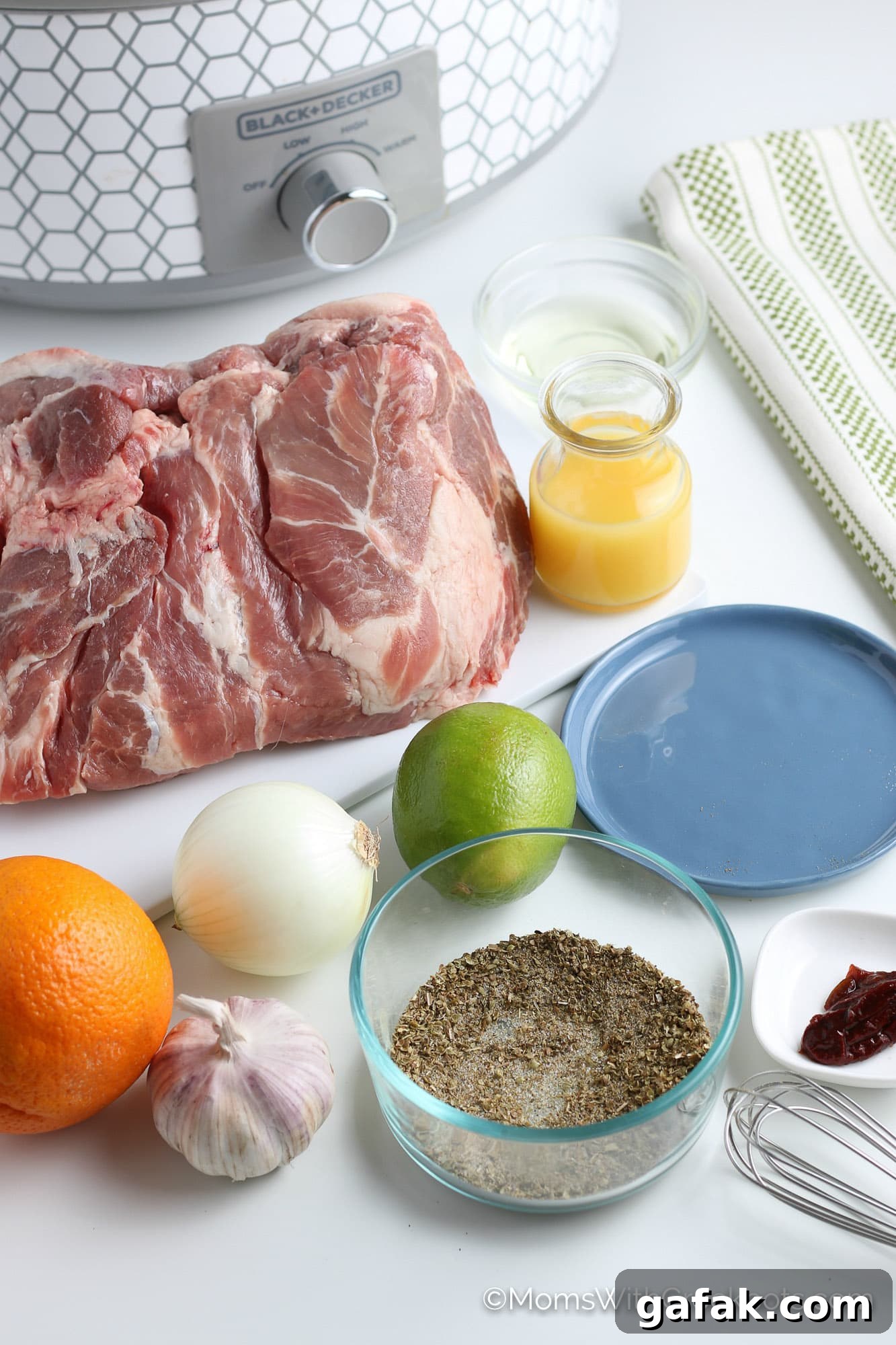 pork roast, orange, and spices, next to crockpot.