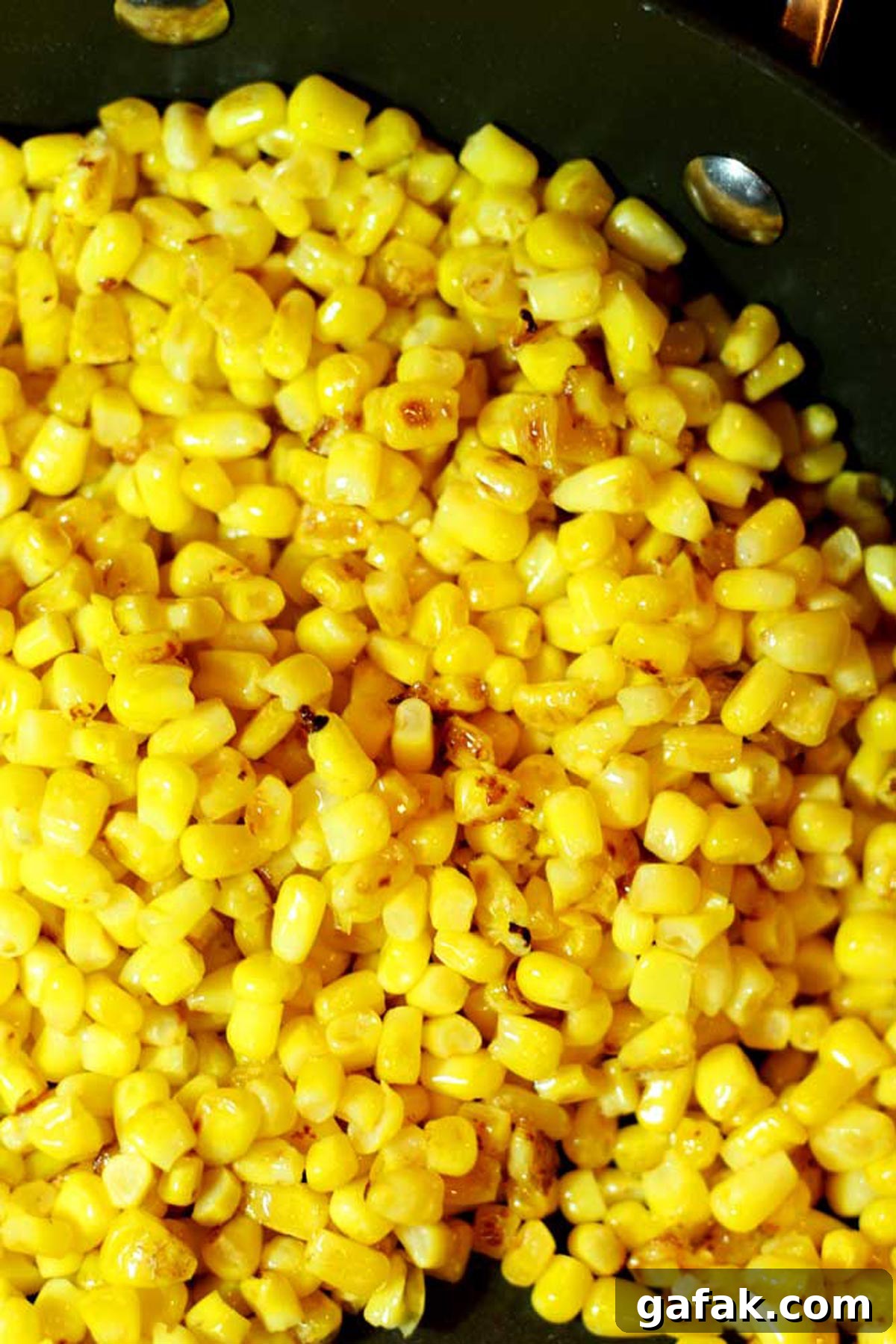 Authentic Mexican Street Corn (Elote) Recipe — Grilled & Creamy 5 Pan containing charred kernels of corn.