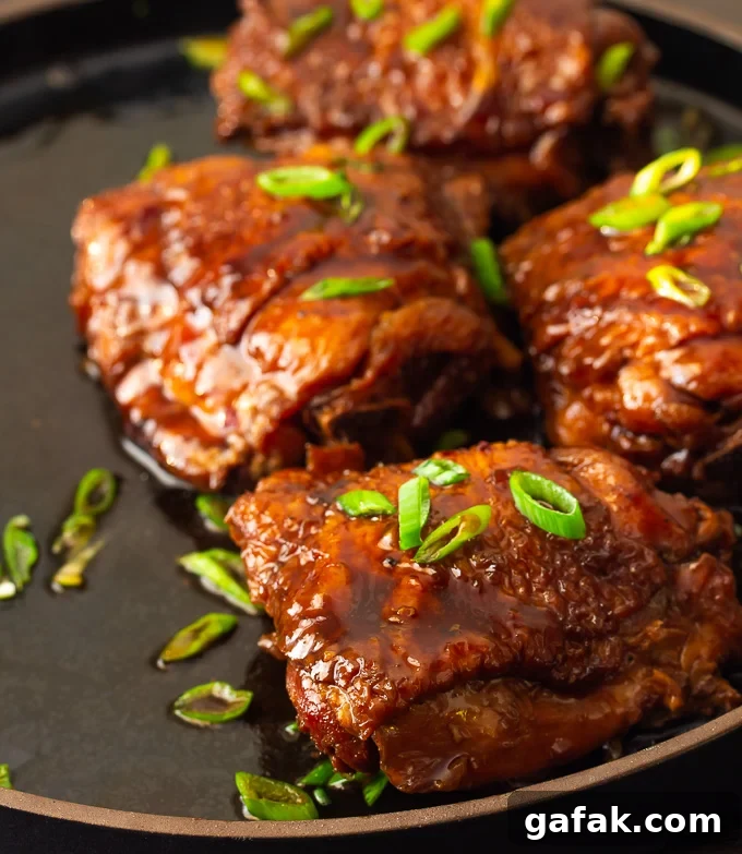 A plate of shoyu chicken with a savory soy-based brown sauce poured over the chicken.