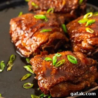 A plate of shoyu chicken with a savory sauce.
