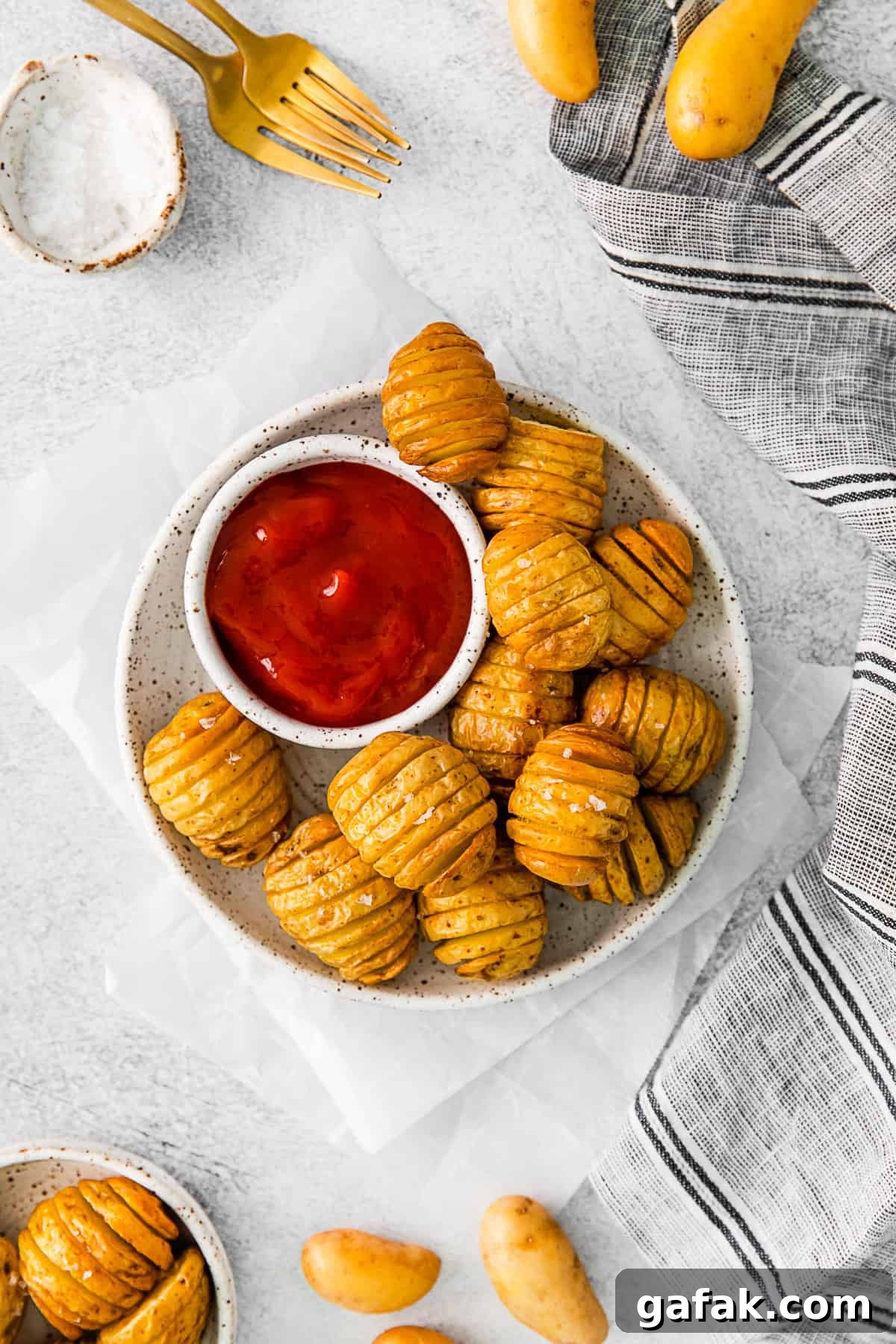 Air Fryer Hasselback Potatoes on a plate with ketchup. 