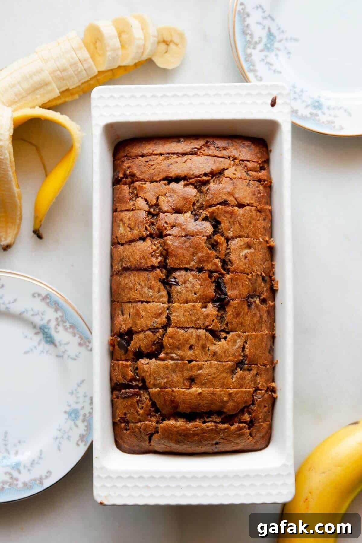 Moist Dairy-Free Banana Bread Recipe (Vegan-Friendly) 2 Soft and moist dairy-free banana bread with chocolate chips sliced in a pan.