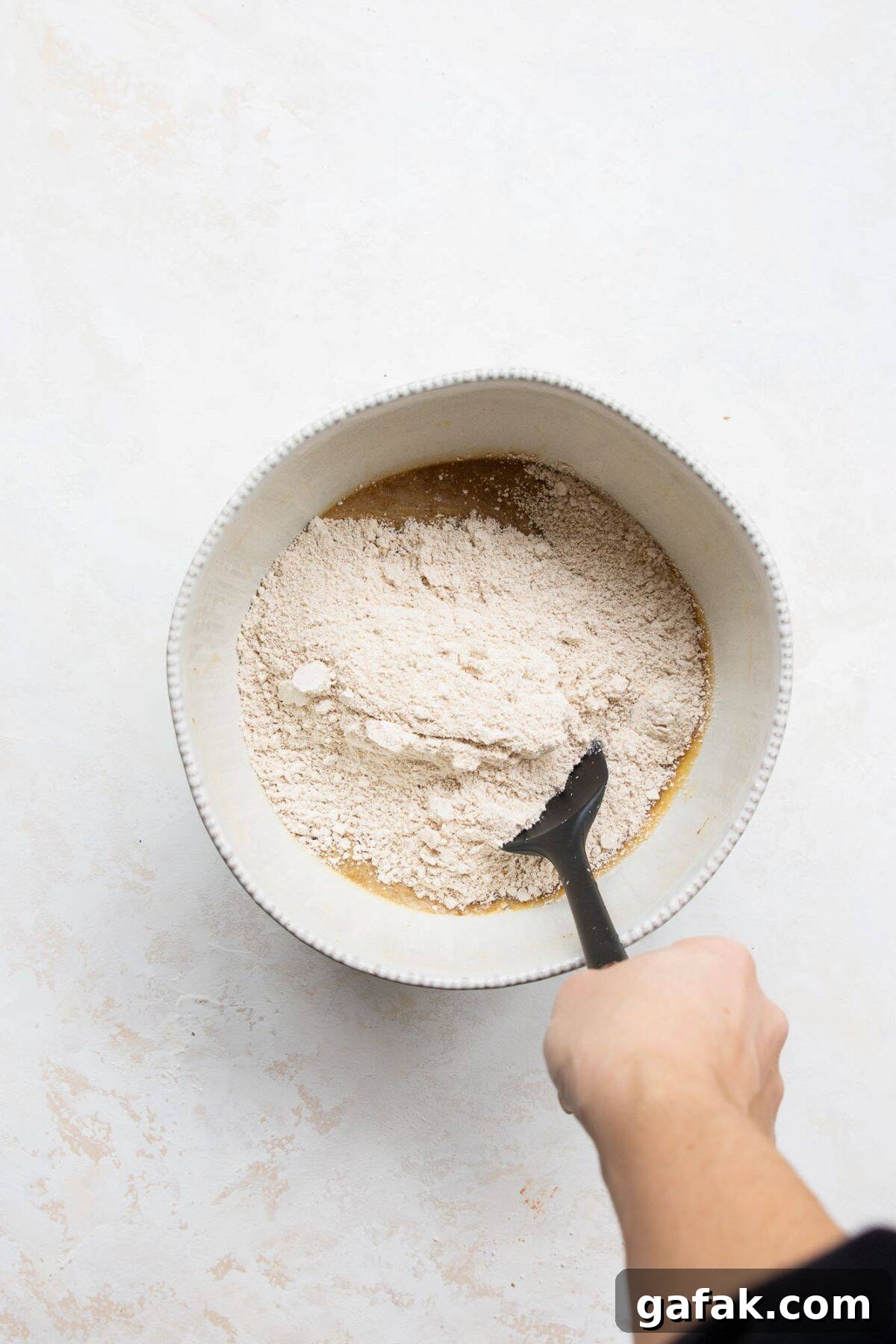 Moist Dairy-Free Banana Bread Recipe (Vegan-Friendly) 4 Folding in flours and dry ingredients to form batter.