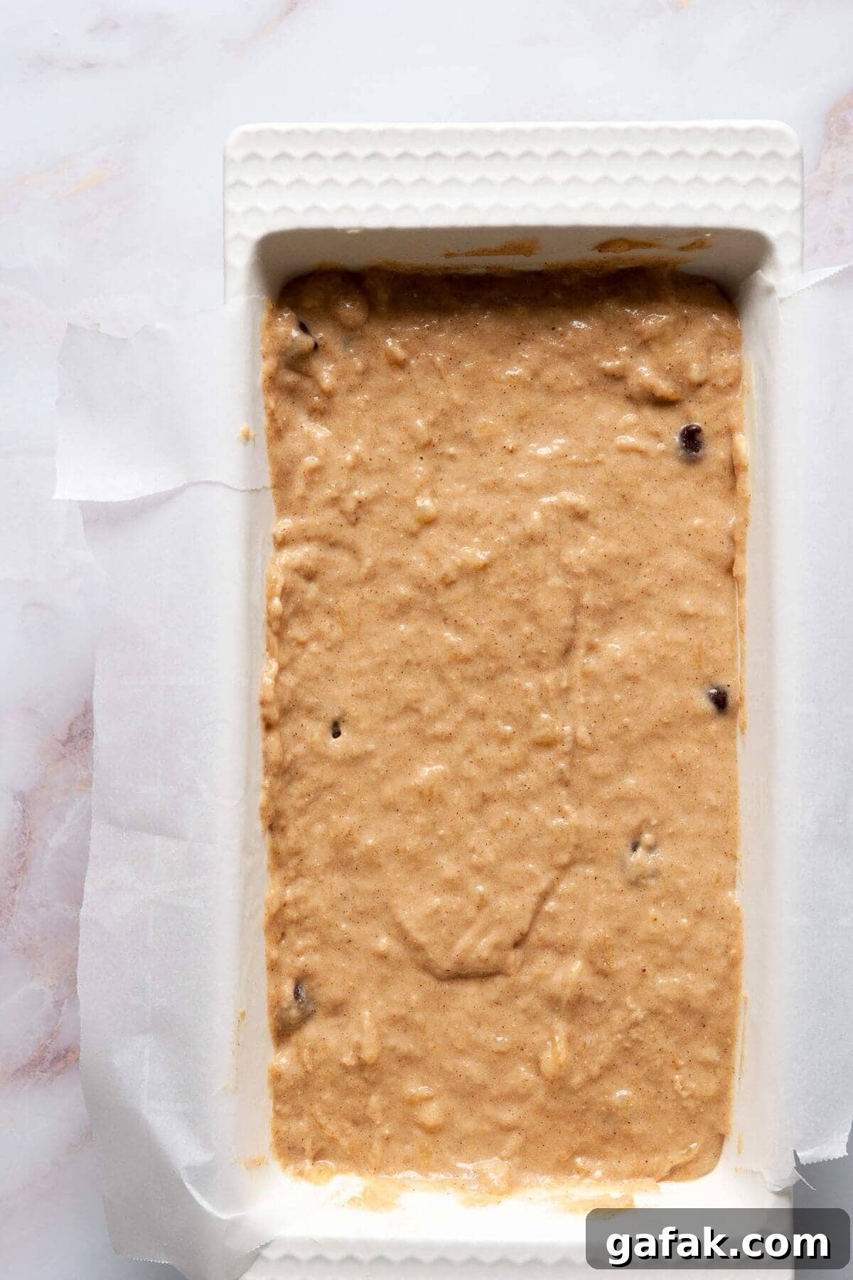 Moist Dairy-Free Banana Bread Recipe (Vegan-Friendly) 6 Dairy-free banana bread batter poured into a parchment-lined loaf pan before baking.