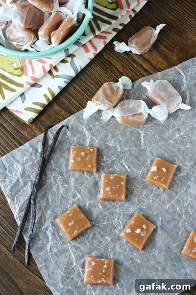Wrapped and unwrapped Vanilla Bean Caramels scattered on parchment.