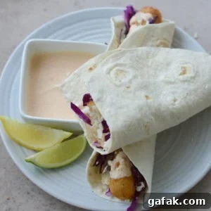 Crispy Air Fryer Fish Tacos with Lime Slaw 8 crispy air fryer fish tacos with a side of sauce and lime wedges